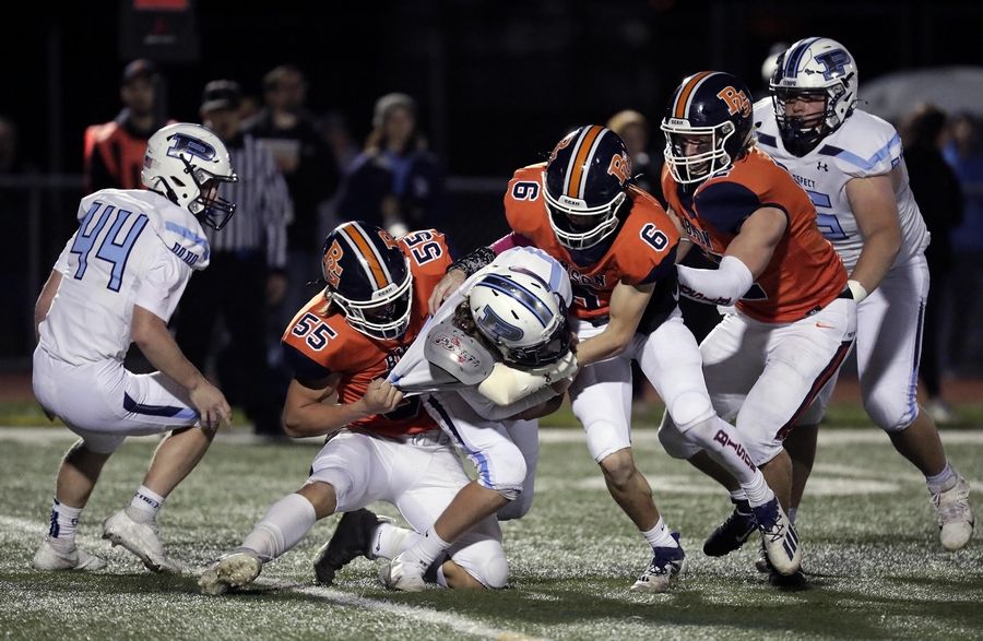 Prospect's Matthew Guza (30) is brought down by Buffalo Grove's Trystan Anderson (55) and Black Juckett (6) during the IHSA Class 7A football playoffs Saturday November 6, 2021 at Buffalo Grove High School.