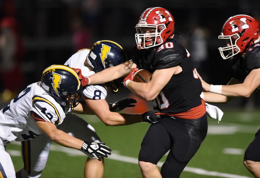 Maine South's Mike Sajenko is met by Glenbrook South's Jack Downing, left, and Trent Spaete as he carries the ball earlier this season. Sajenko and the Hawks travel to Marist Saturday for a Class 8A semifinal playoff game.