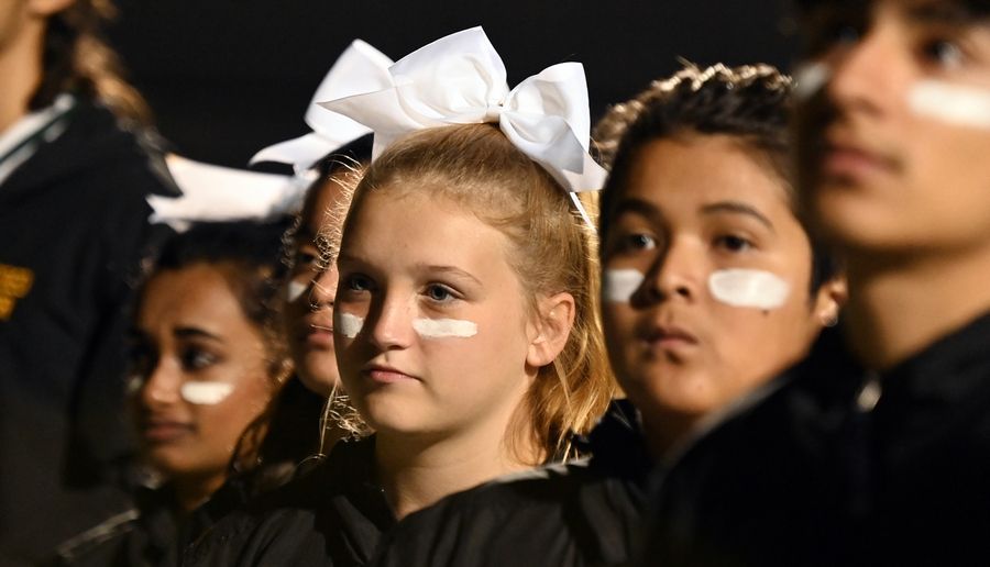 During the national anthem, third from right is Lara Penar, 14, an Elk Grove High School freshman from Elk Grove Village. Images from varsity football action at Elk Grove High School on Sept. 30, 2022.